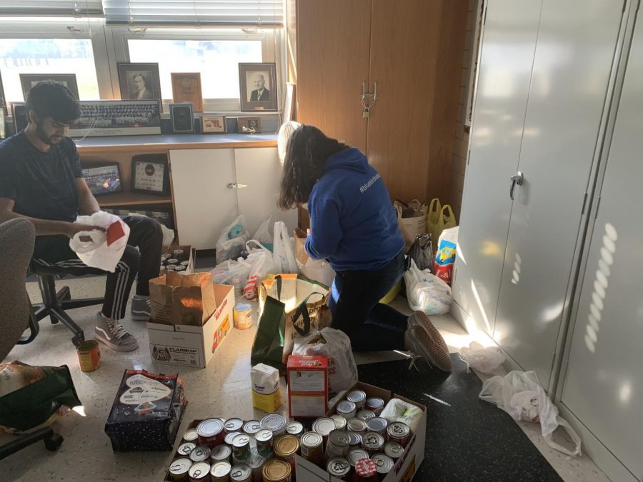 NHS President Shawaiz Abbasi and Vice President Caroline Harris sort and organize all the food donated during the Thanksgiving holiday food drive. 
